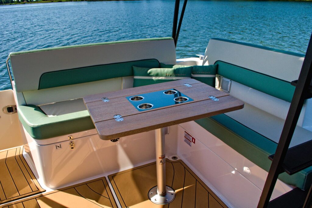 Strefa wypoczynkowa jachtu GoldYacht z zielonymi kanapami i stolikiem na Jeziorze Rożnowskim